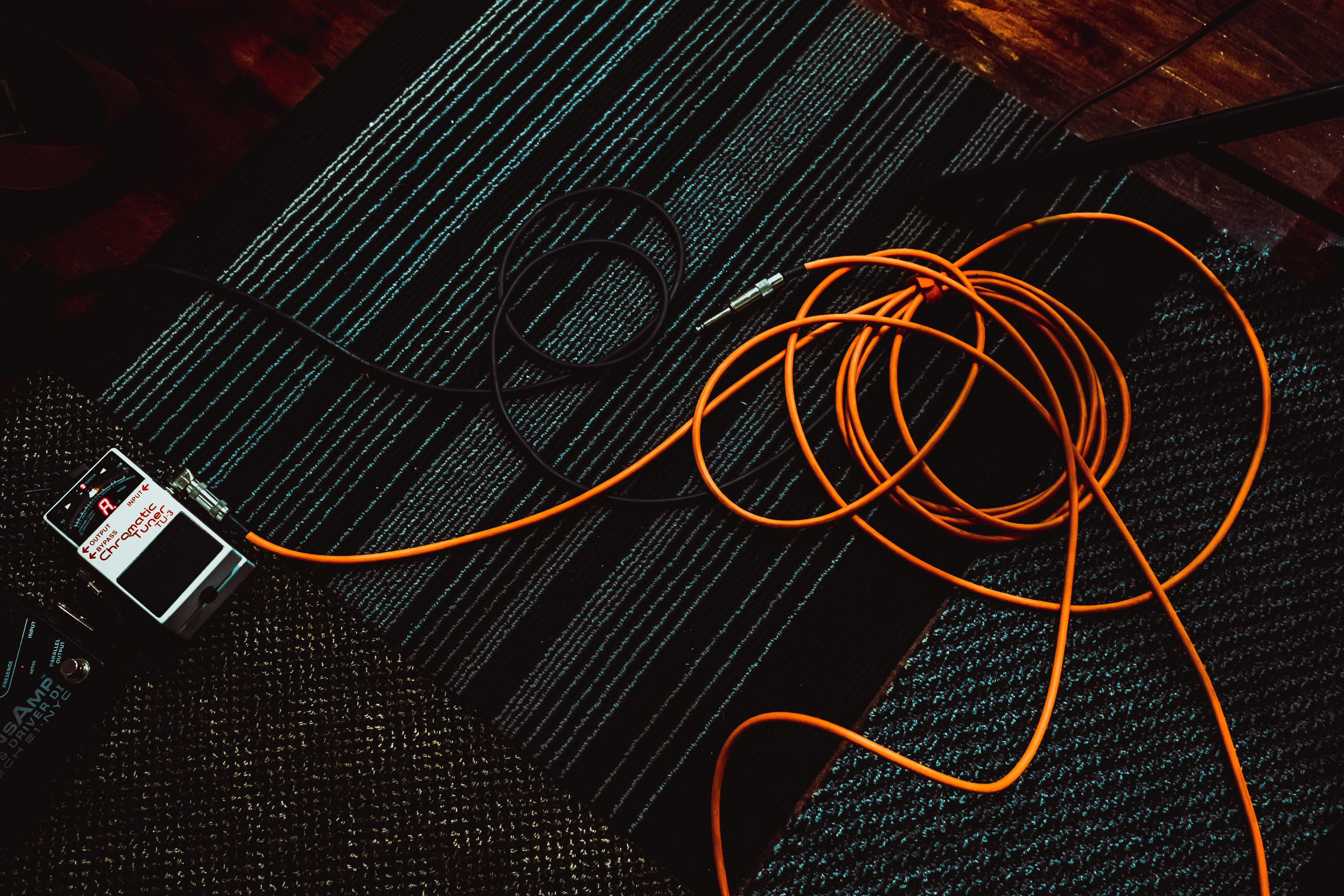 Tangled audio cables on a dark surface, representing podcast audio equipment