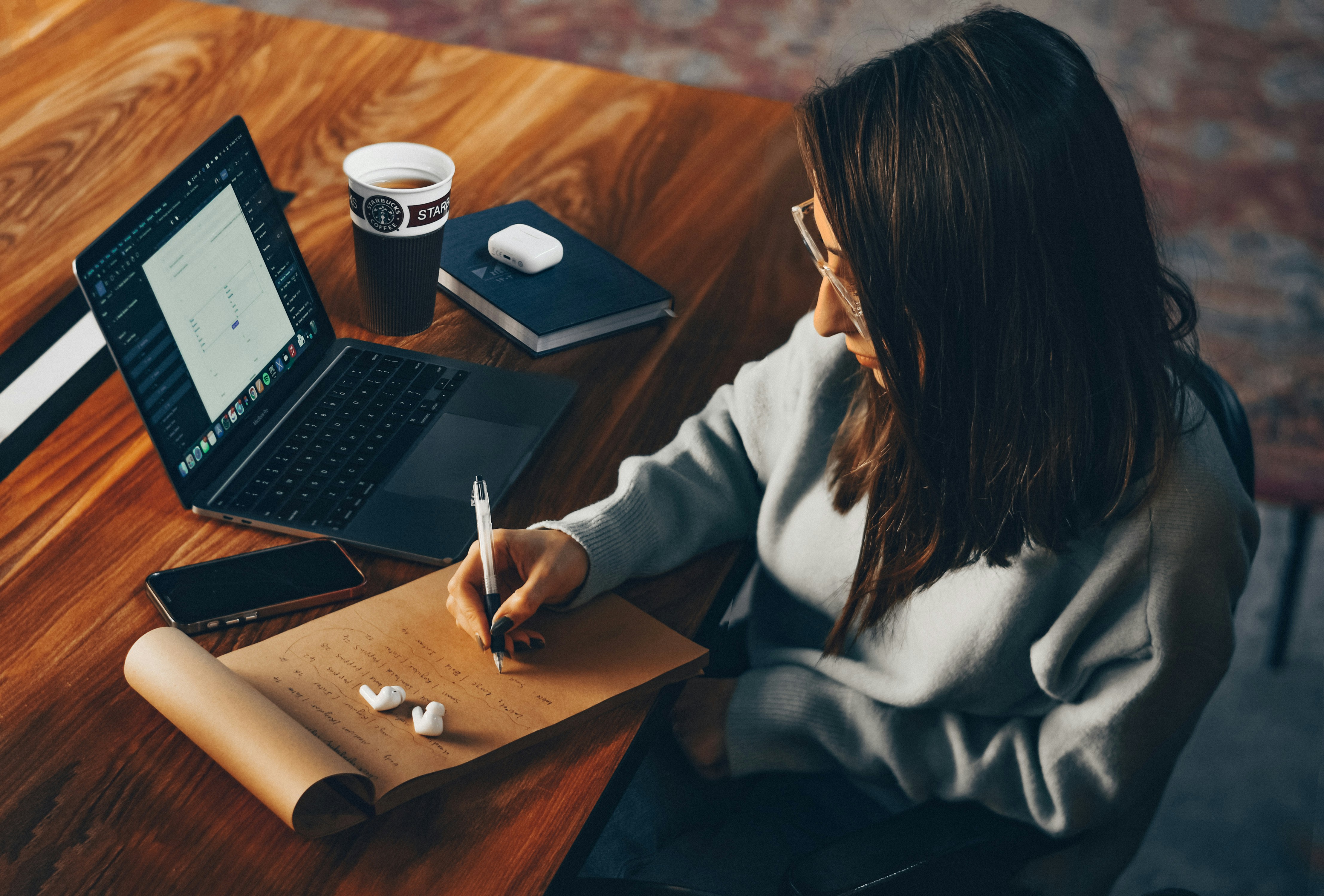 Young woman working remotely with laptop and notebook, perfect for podcast content creation