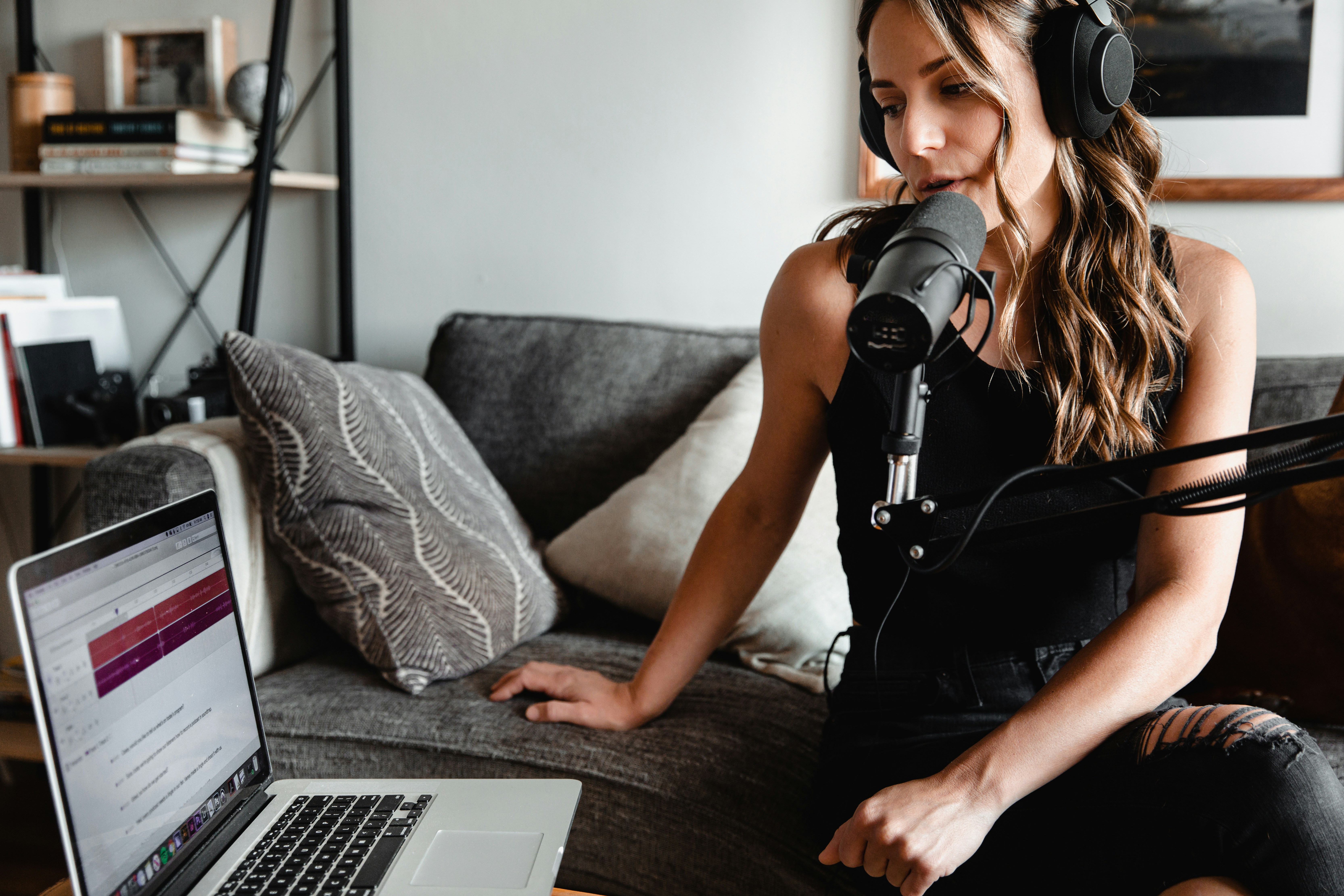 Female podcaster recording comfortably from a home living room setup