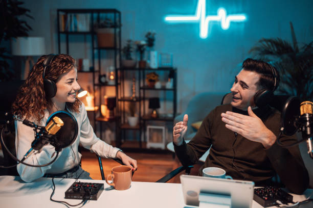 Two podcast hosts recording a conversation in a cozy studio