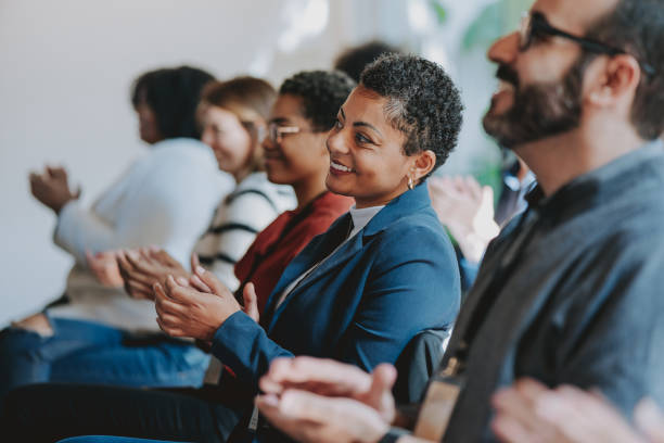 Diverse audience clapping at a business conference seminar
