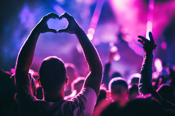 Concert crowd with hands forming a heart shape at a music festival